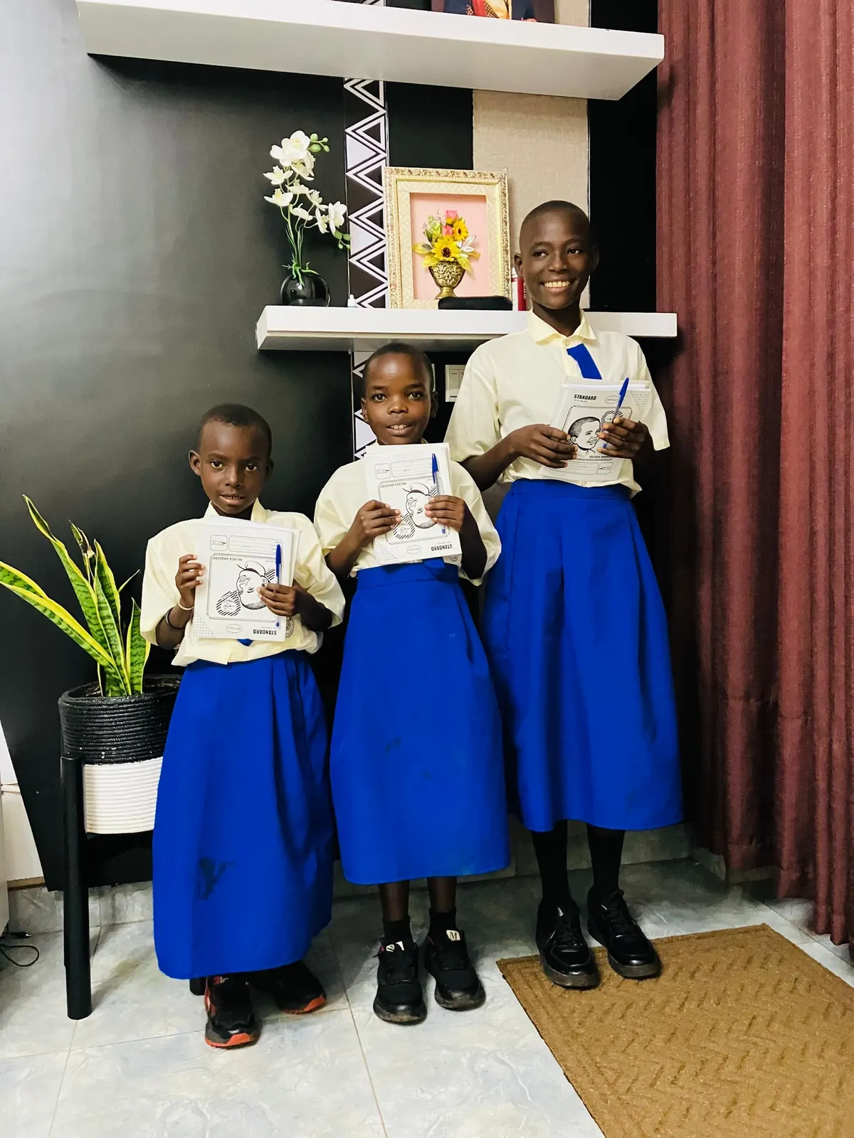 Three schoolchildren in uniform holding cards