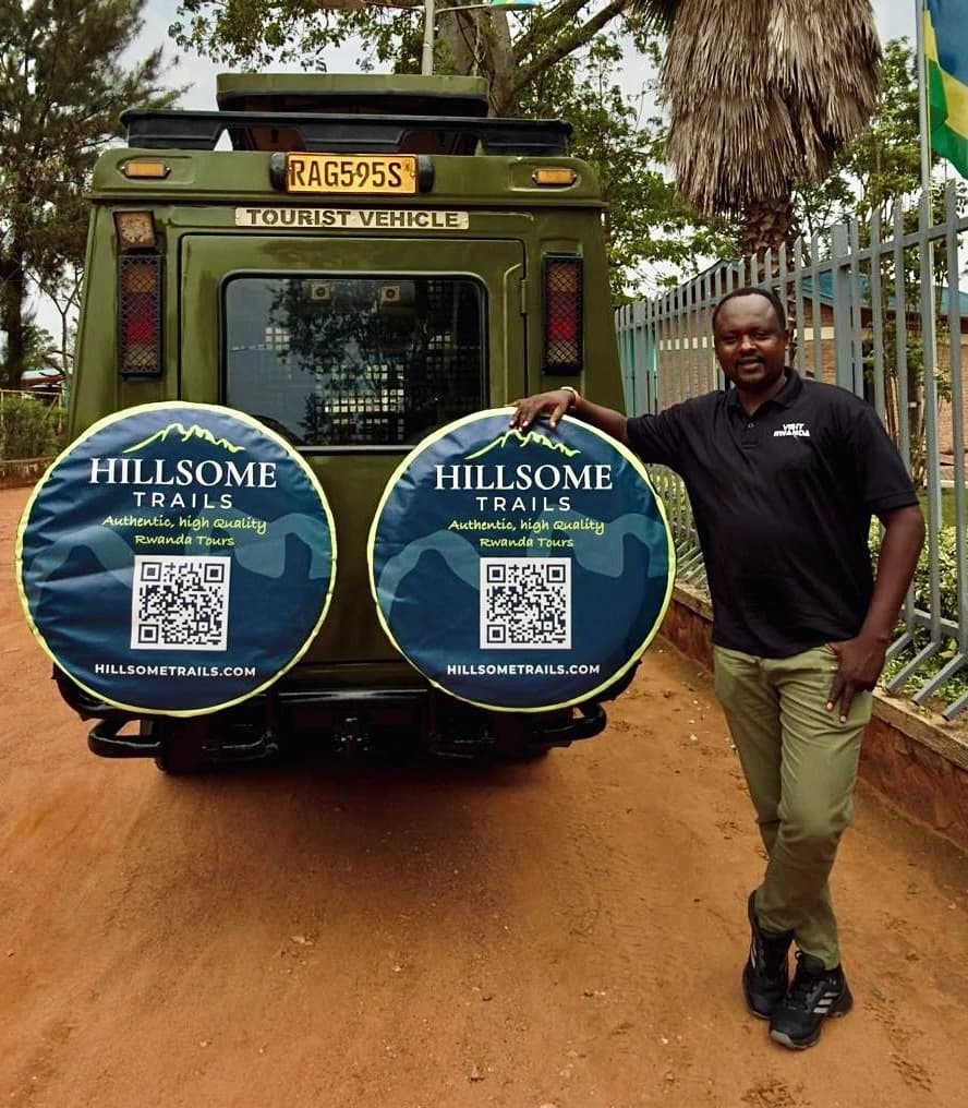 Two travellers standing between Hillsome Trails safari vehicles