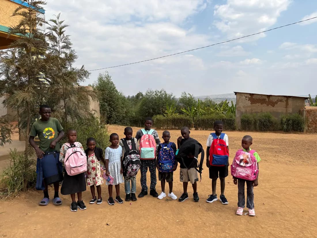 Children standing together outdoors with colourful school backpacks